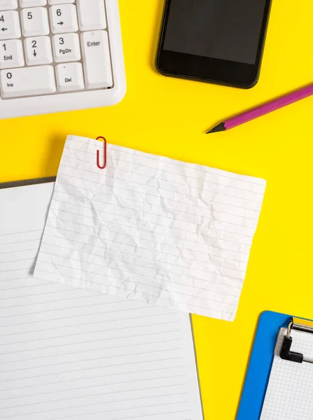 Imagem de conceito de negócio com papel em branco para mensagens de texto. Papel branco esmigalhado vazio com espaço de cópia na mesa com clipes de papel relógio celular e teclado pc . — Fotografia de Stock