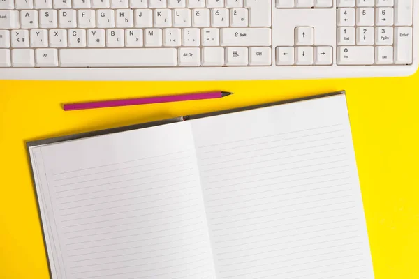 Kopiera utrymme på anteckningsboken ovan gul bakgrund med PC-tangentbord och penna på bordet. Tomt vitt papper för text meddelanden. — Stockfoto