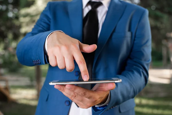 Homme d'affaires dans la suite bleue avec une cravate tient le haut de tour dans les mains. Concept d'entreprise avec l'homme dans une suite et un ordinateur portable . — Photo