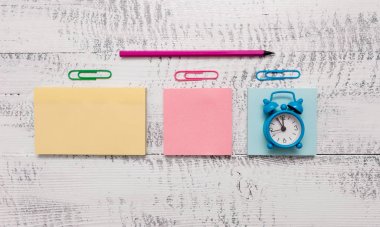 Üç çok renkli boş not defterleri küçük çalar saat marker klipler tükenmez ahşap vintage arka plan boş metin önemli olaylar ofis okul ev