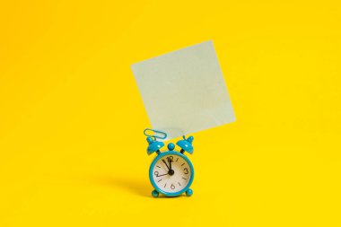 Metal retro vintage çalar saat uyandırma boş kare yapışkan not küçük kağıt levha renkli arka plan Boş metin önemli olaylar ev ofis okul günlük