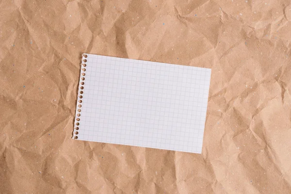 Bureau gemaakt van verfrommeld karton met verschillende soorten en maten leeg papier. Papercraft tafel met wat papieren en studiemateriaal en kantoorapparatuur. — Stockfoto