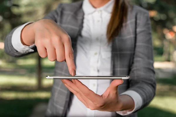 Outdoor scene with business woman holds lap top with touch screen. Business concept with woman on outdoor scene.