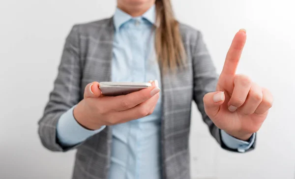 Donna d'affari tiene in mano il cellulare. Concetto di business con cellulare e donna d'affari. Bella donna in una suite d'affari con telefono . — Foto Stock