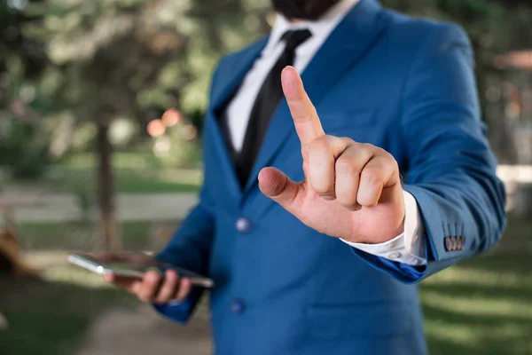 Affärsman med pekfingret framför sig. Affärsmannen håller Lap Top i handen och pekar med fingret. — Stockfoto