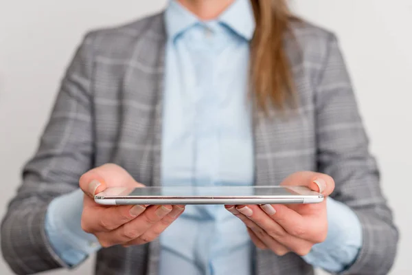 Mujer de negocios sostiene el teléfono móvil en la mano. Concepto de negocio con teléfono móvil y mujer de negocios. Mujer guapa en una suite de negocios con teléfono . — Foto de Stock