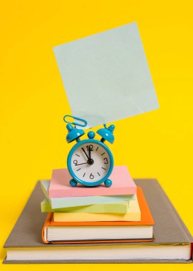 Metal retro vintage çalar saat uyandırma boş kare yapışkan not eski kitaplar çok renkli yığılmış not defterleri renkli arka plan Boş metin önemli olaylar günlük