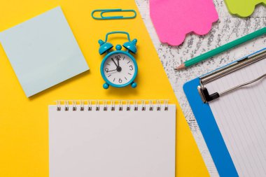 Closeup ön görünüm boş spiral not defteri kalem küçük çalar saat harf boyutu klip renkli kağıt levha araba yapışkan notlar pad pano ahşap retro arka plan boş metin önemli olaylar