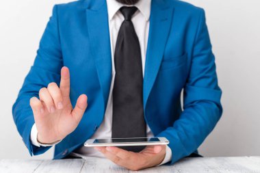 Önünde parmağını gösteren bir işadamı. İşadamı elinde tur üst tutar ve parmağıyla puan.