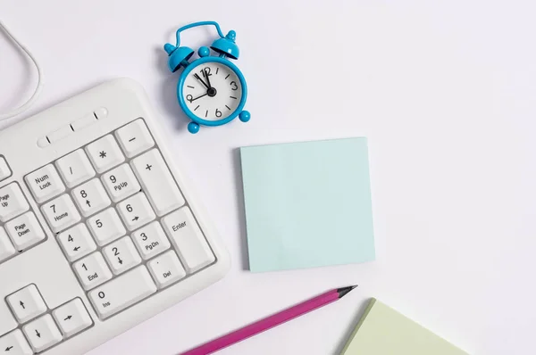 Clavier pc blanc avec papier de note vide et horloge au-dessus du fond blanc. Concept d'entreprise avec notes et clavier PC. Espace papier vierge pour message textuel . — Photo