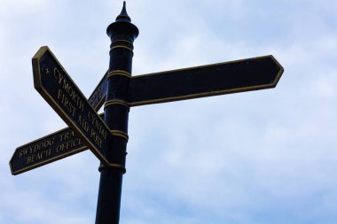 Arka planda mavi bulutlu gökyüzü ile kavşakta yol işareti. Crossroad tabelası ve mavi arka plan ile seyahat konsepti.
