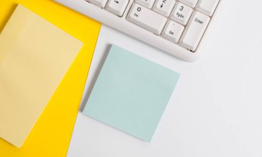 Turuncu arka plan masasının üzerinde kopya alanı ve bilgisayar klavyesi içeren boş kağıt boş kağıt. Metin mesajı için kopya alanı renkli kağıt ile iş kavramı.