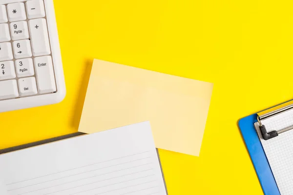 Tomma orange papper med kopieringsutrymme på det gula bordet. Tomma papper för textmeddelanden. Affärsidé med tomma papper på bordet. — Stockfoto