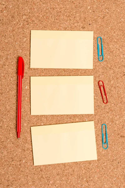 세 개의 수직 빈 스티커 노트, 사무 기기 및 연구 용품이있는 코르크 보드 책상. 직립, 사각형 모양, 첨부 된 종이 알림 메모와 빌보드. — 스톡 사진