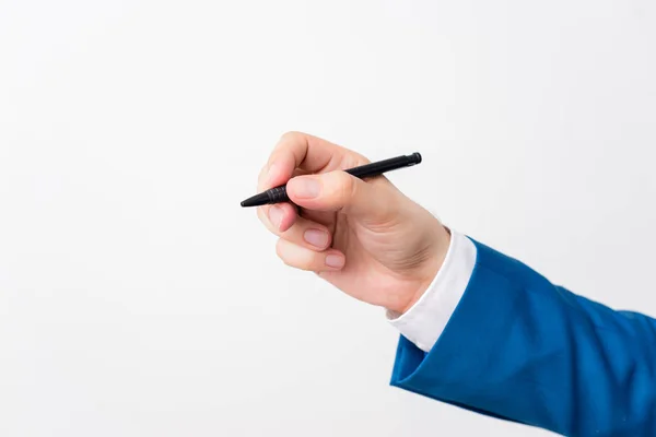 Isolated hand above white background hold pen. Pointing pen in the hand above white background. Business concept with copy space above white background.