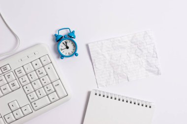 Masada saati ve klavyesi olan boş bir kağıt. Pc klavyesi ve boş not kağıdıyla iş konsepti resmi.