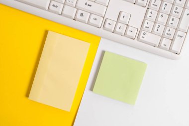 Turuncu arka plan masasının üzerinde kopya alanı ve bilgisayar klavyesi içeren boş kağıt boş kağıt. Metin mesajı için kopya alanı renkli kağıt ile iş kavramı.