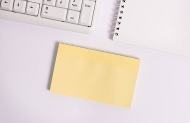 Kopya alanı ile pc klavyesi tarafından beyaz arka plan üzerinde boş not kağıdı. Metin mesajları için boş kağıdın üzerine düz yat.