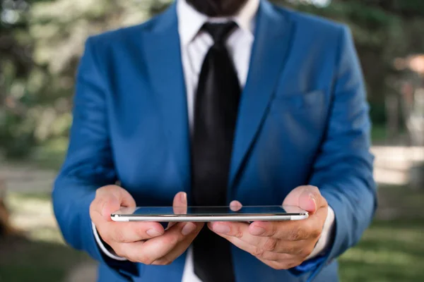 Affärsman i Blue Suite med en slips håller Lap Top i händerna. Affärsidé med man i en svit och en lap top. — Stockfoto