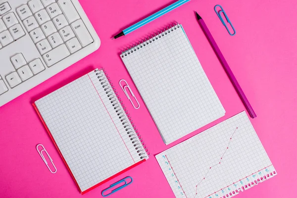 Equipements d'écriture et d'informatique ainsi que du papier mathématique placé sur une toile de fond colorée. Stationnaire, livre de mathématiques près des outils de la machine de traitement de l'information au-dessus de la table ordinaire. — Photo