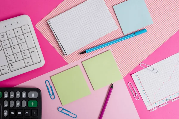 Equipements d'écriture et d'informatique ainsi que du papier mathématique placé sur une toile de fond colorée. Stationnaire, livre de mathématiques près des outils de la machine de traitement de l'information au-dessus de la table ordinaire. — Photo