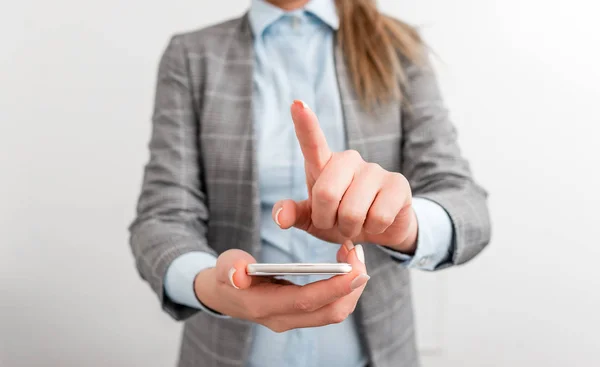 Donna d'affari tiene in mano il cellulare. Concetto di business con cellulare e donna d'affari. Bella donna in una suite d'affari con telefono . — Foto Stock