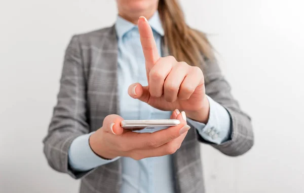 Mujer de negocios sostiene el teléfono móvil en la mano. Concepto de negocio con teléfono móvil y mujer de negocios. Mujer guapa en una suite de negocios con teléfono . —  Fotos de Stock