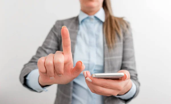 Donna d'affari tiene in mano il cellulare. Concetto di business con cellulare e donna d'affari. Bella donna in una suite d'affari con telefono . — Foto Stock