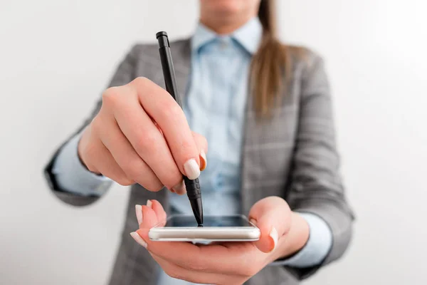 Zakenvrouw die met pen wijst op het mobiele aanraakscherm. Business concept image met zakenvrouw houdt potlood. — Stockfoto