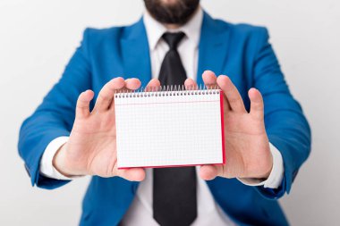 Adam önünde kopya alanı olan boş bir kâğıt tutuyor. Süitteki adam ve kravatlı iş konsepti. Reklam iletisi için beyaz alan.