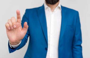 Mavi süitli işadamı ve boş alanda parmakla işaret eden beyaz gömlekli. İşadamının parmakla işaret ederek alan kopyalaması. Süitte adam ile iş konsepti.