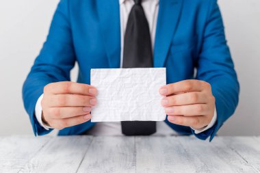 Adam önünde kopya alanı olan boş bir kâğıt tutuyor. Süitteki adam ve kravatlı iş konsepti. Reklam iletisi için beyaz alan.