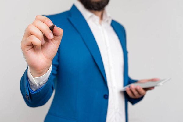Businessman in blue suite and white shirt pointing with finger in empty space. Copy space with businessman pointing with finger. Business concept with man in the suite.