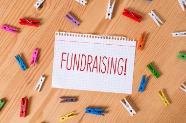 Kelime yazma metin Fundraising. Hayır için mali destek oluşturmak veya neden Renkli clothespin kağıtları boş hatırlatma ahşap zemin arka plan ofis arayan için Iş kavramı.