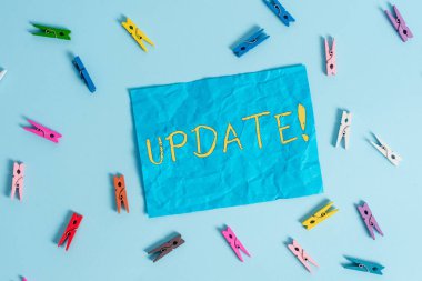 Kelime yazma metni Güncelleştir. Yazılım programı gibi bir şey daha modern ya da güncel hale getirmek için Iş konsepti Renkli clothespin dikdörtgen şekilli hatırlatma kağıt açık mavi arka plan.
