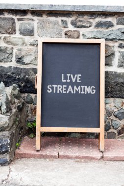 El yazısı metin yazma Live Streaming. Kavram anlamı Reklam için kopya alanı ile Internet Boş siyah tahta üzerinden bir olayın canlı video kapsama İletim. Boş karanlık tahta.
