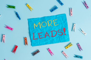 Kelime yazma metni Daha Fazla Müşteri Adayı. Ürün veya hizmetlere başlatma tüketici faiz iúlemi için iş konsepti Renkli clothespin dikdörtgen şekilli hatırlatma kağıt açık mavi arka plan.