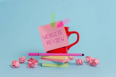 Web Sitesi İnceleme gösteren not yazma. İş fotoğraf vitrin İşletmeler ve hizmetler hakkında gönderilebilir Yorumlar Kahve fincanı kalem notu afiş yığılmış pedleri kağıt topları pastel arka plan.