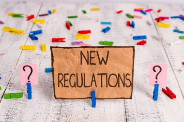 Yeni Düzenlemeler sorusunu gösteren kavramsal el yazısı. İş fotoğraf metin kuralları bir şey ahşap masaya yerleştirilen ataş ile crumbling levha yapılır şekilde kontrol etmek için hükümet sipariş yaptı.