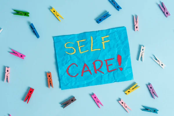 Słowo pisanie tekstu Self Care. Koncepcja biznesowa dla praktyki podejmowania działań w celu zachowania lub poprawy własnych zdrowia kolorowe clothespin prostokąt w kształcie przypomnienie papieru światło niebieskie tło. — Zdjęcie stockowe