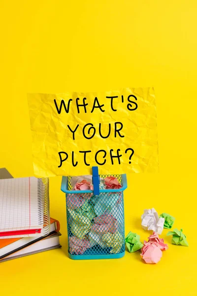 Conceptual hand writing showing What S Is Your Pitch question. Business photo showcasing asking about property of sound or music tone Trash bin crumpled paper clothespin office supplies yellow.