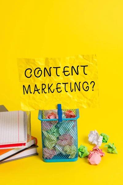 Conceptual hand writing showing Content Marketing question. Business photo showcasing involves creation and sharing of online material Trash bin crumpled paper clothespin office supplies yellow.