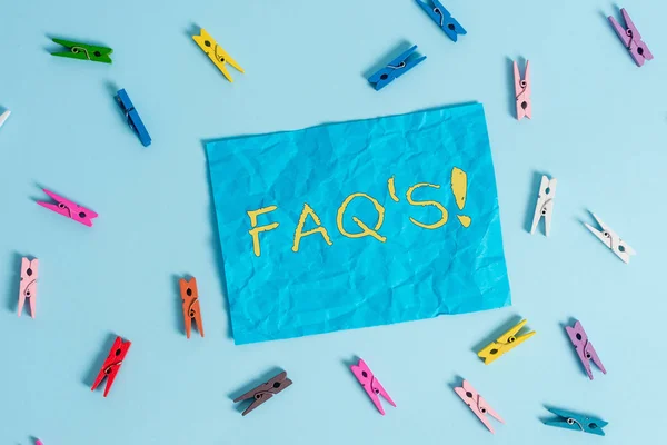Ord skrivning text FAQ S. affärsidé för lista med frågor och svar om särskilda ämne färgade klädnypa rektangel formad påminnelse papper ljusblå bakgrund. — Stockfoto