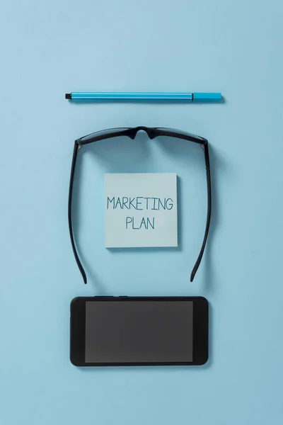 Signo de texto que muestra Plan de Marketing. Foto conceptual Documento completo de actividades comerciales y publicidad Gafas oscuras coloreadas nota adhesiva lápiz de teléfono inteligente fresco fondo pastel . — Foto de Stock