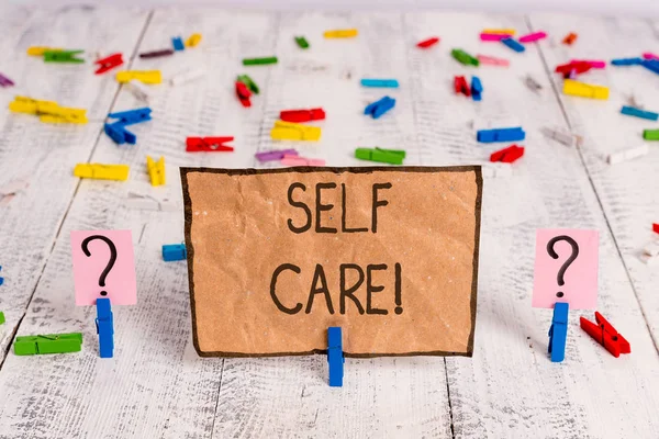 Conceptual hand writing showing Self Care. Business photo text practice of taking action to preserve or improve ones own health Crumbling sheet with paper clips placed on the wooden table. — Stock Photo, Image