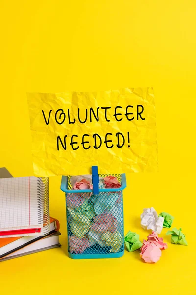Conceptual hand writing showing Volunteer Needed. Business photo showcasing need work for organization without being paid Trash bin crumpled paper clothespin office supplies yellow.