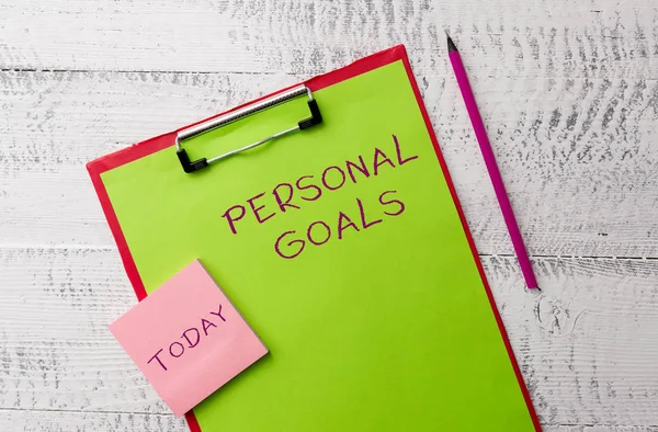 Word writing text Personal Goals. Business concept for Target set by a demonstrating to influence his efforts Motivation Metal clipboard paper sheets marker sticky notes pad wooden background.