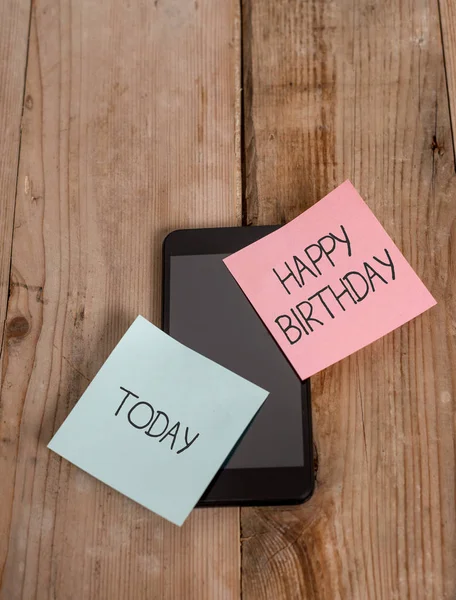 Tekst pisma odręcznego Happy Birthday. Pojęcie znaczenie rocznica urodzenia demonstracji obchodzony jest z prezentami smartphone dwa kolorowe samoprzylepne notatki leżące zabytkowe Stare drewniane tło. — Zdjęcie stockowe