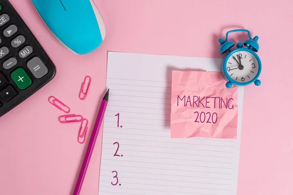 마케팅 2020을 보여주는 개념적 손 쓰기. 2020 년 새해 프로모션 이벤트 계산기 시계 마우스 분쇄 노트 연필 색상 배경에 대한 상업 동향을 보여주는 비즈니스 사진. — 스톡 사진