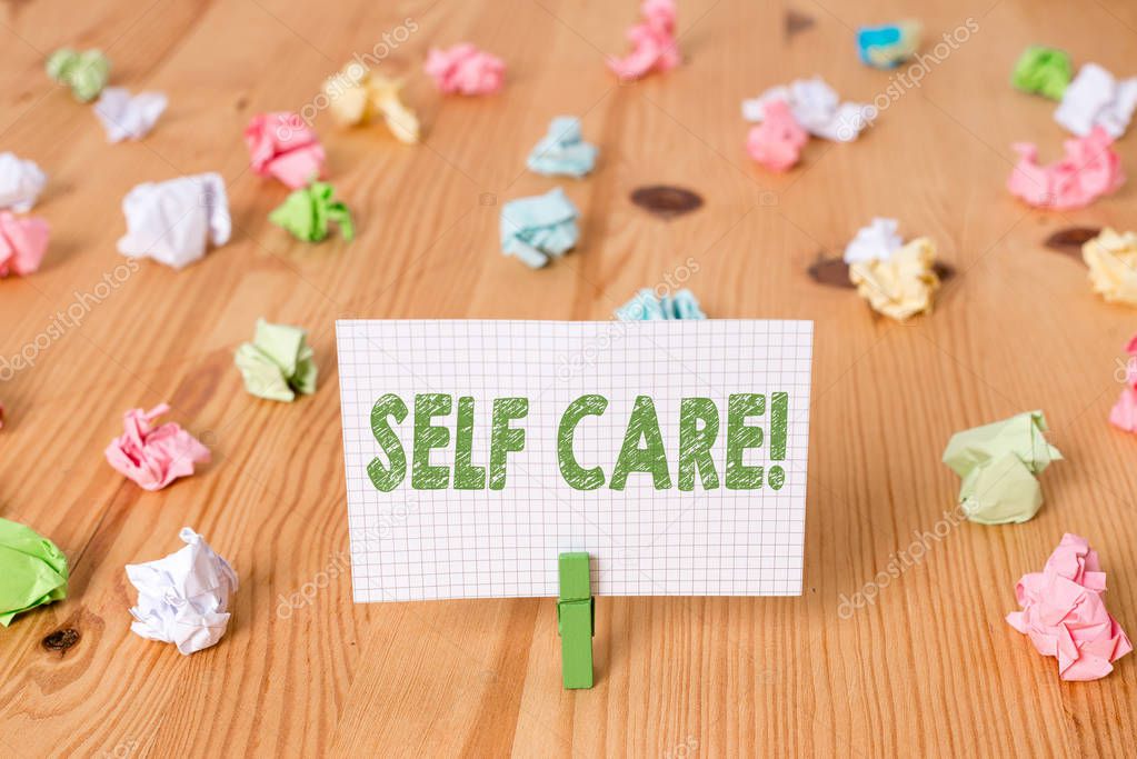 Conceptual hand writing showing Self Care. Business photo showcasing practice of taking action to preserve or improve ones own health Colored crumpled papers wooden floor background clothespin.